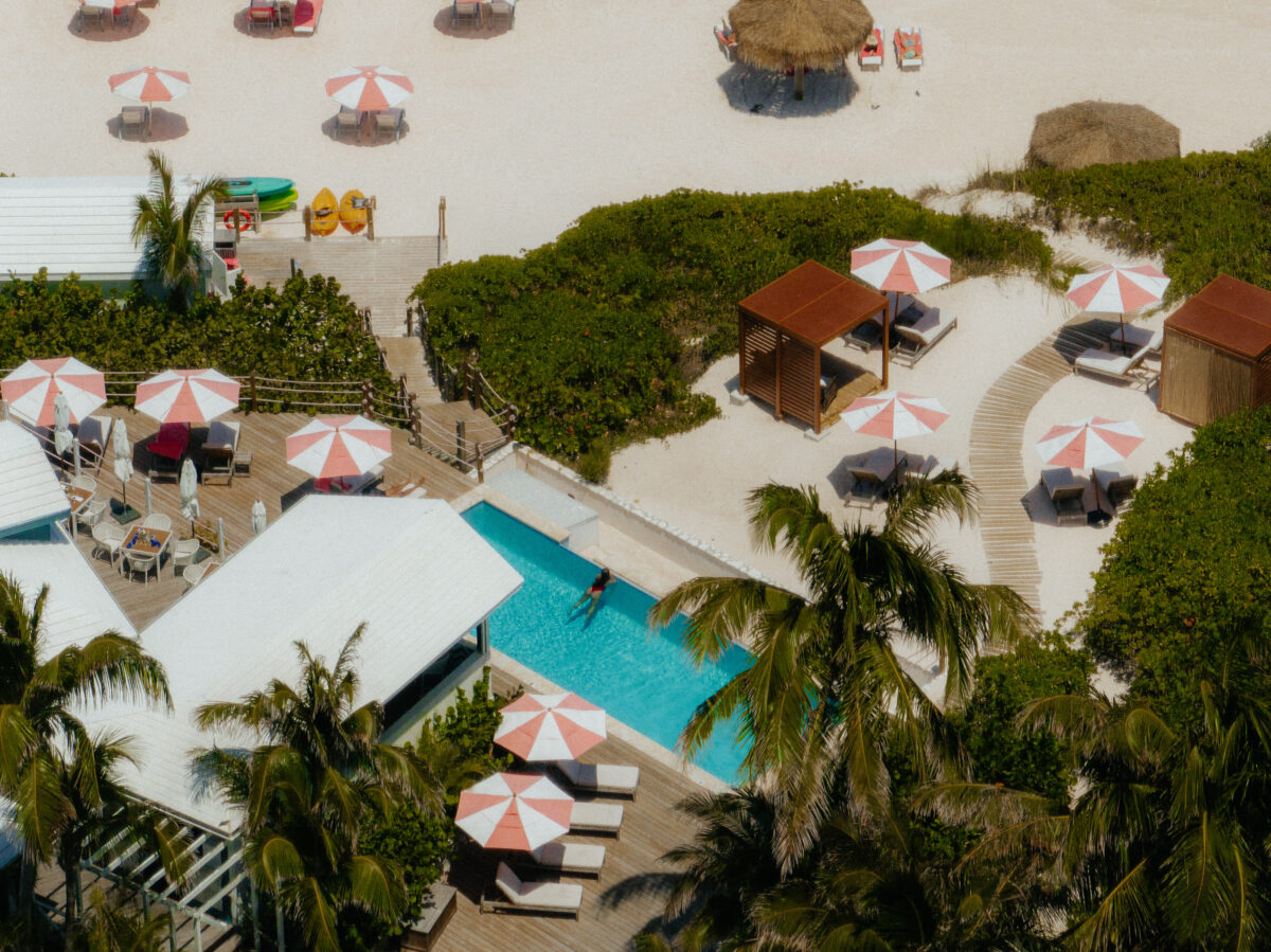 pool aerial shot with red and white umbrellas